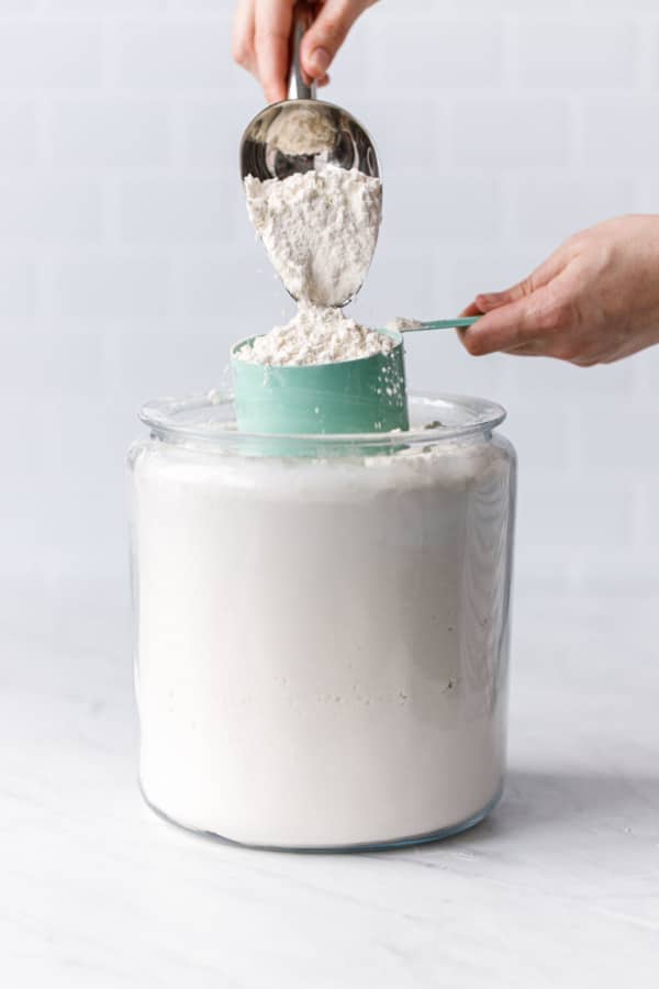 Scoop the flour out of its container and sprinkle it over your measuring cup.