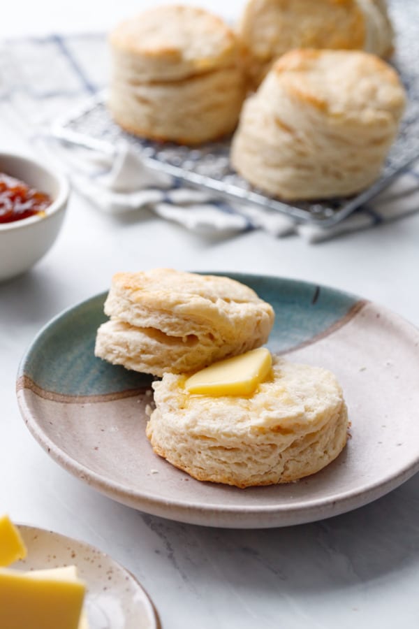 Flaky sourdough biscuit split in half with a pat of butter