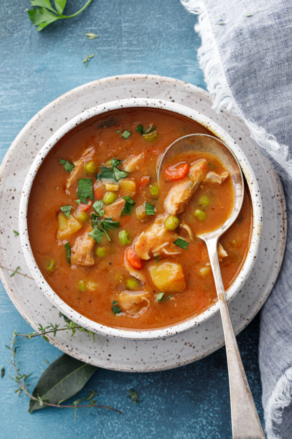 Overhead view of a spoon in a bowl of hearty turkey stew