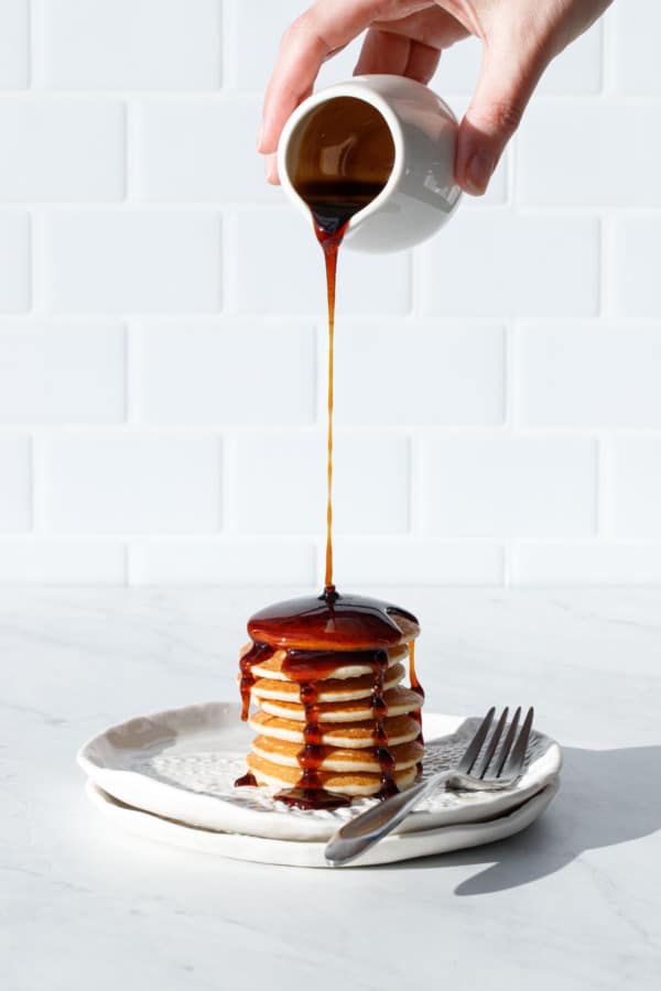 Homemade Fig Syrup poured over a stack of silver dollar pancakes