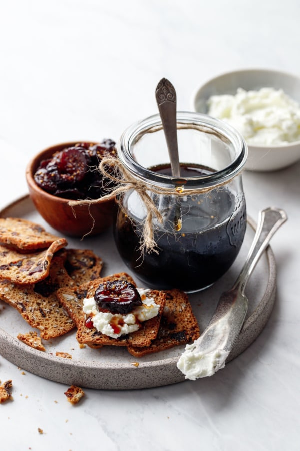Homemade Fig Syrup, served on crackers spread with goat cheese and topped with a slice of dried fig
