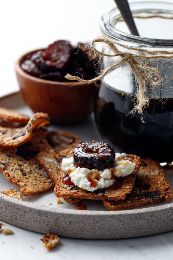 Homemade Fig Syrup, served on crackers spread with goat cheese and topped with a slice of dried fig