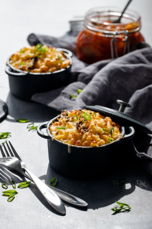 Kimchee Macaroni & Cheese in black ramekins with a jar of kimchi