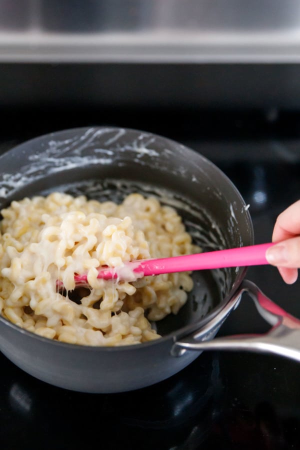 Stirring a Pot of macaroni and cheese with kimchi