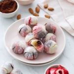 Plate with Neapolitan Amaretti Cookies, and bowls of strawberries, cocoa poweder and almonds.