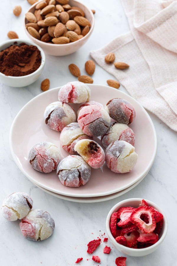 Plate with Neapolitan Amaretti Cookies, and bowls of strawberries, cocoa poweder and almonds.