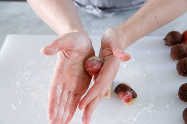 Rolling balls of marbled dough for Neapolitan Amaretti Cookies