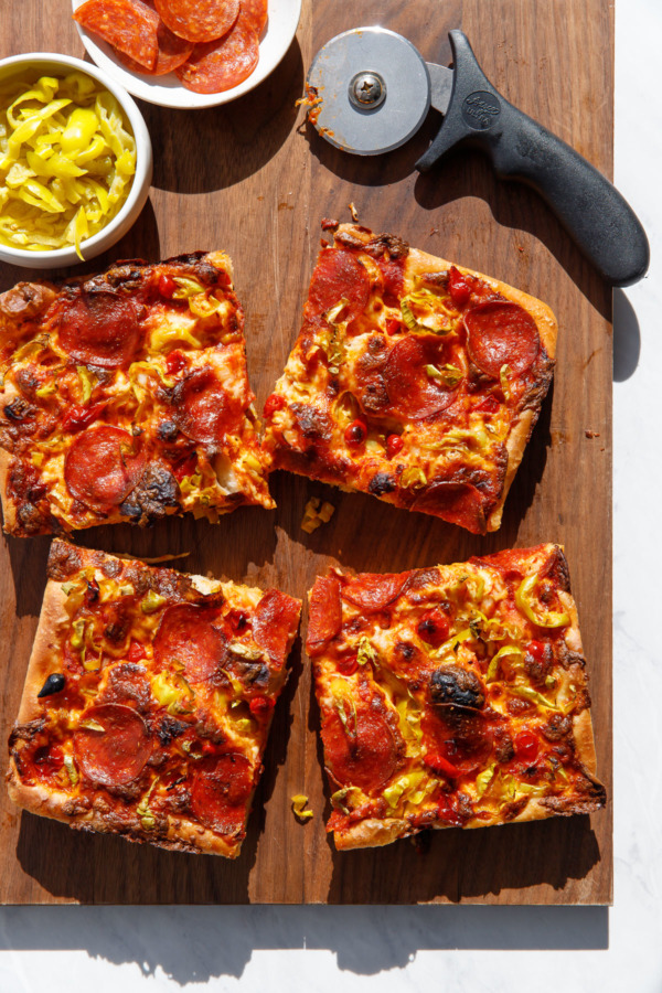 Overhead shot of slices of pepperoni pan pizza with harsh shadows