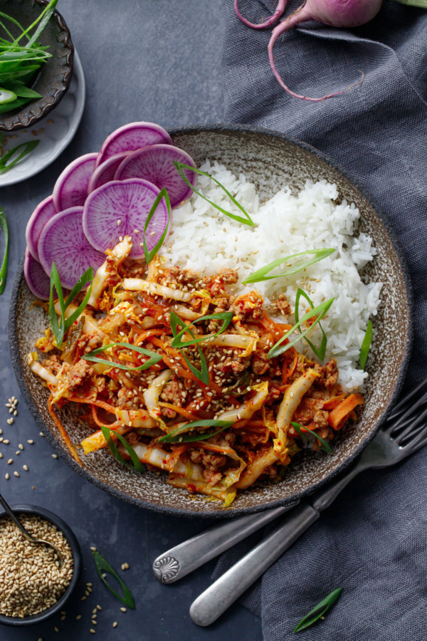 Overhead shot of a bowl of Spicy Korean Egg Roll Bowls with rice and radishes