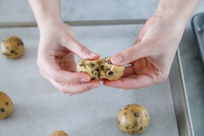 Splitting a ball of cookie dough in half to stuff.