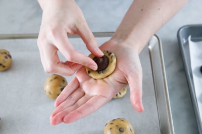 Pressing the frozen ganache center in the middle of the cookie dough.