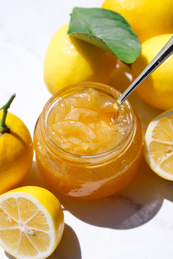 Jar of Old-Fashioned Meyer Lemon Marmalade with whole and half lemons