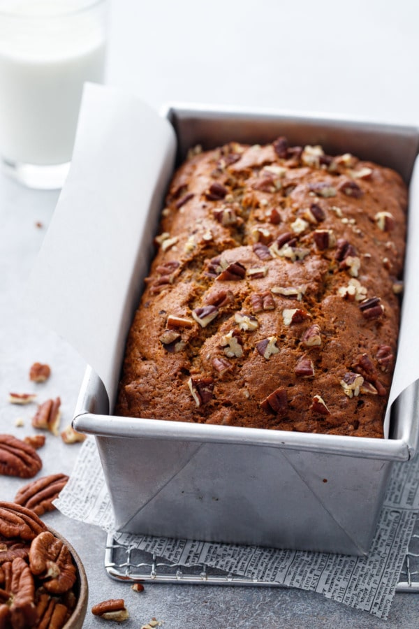 Loaf pan with Bananas Foster Banana Bread and chopped pecans
