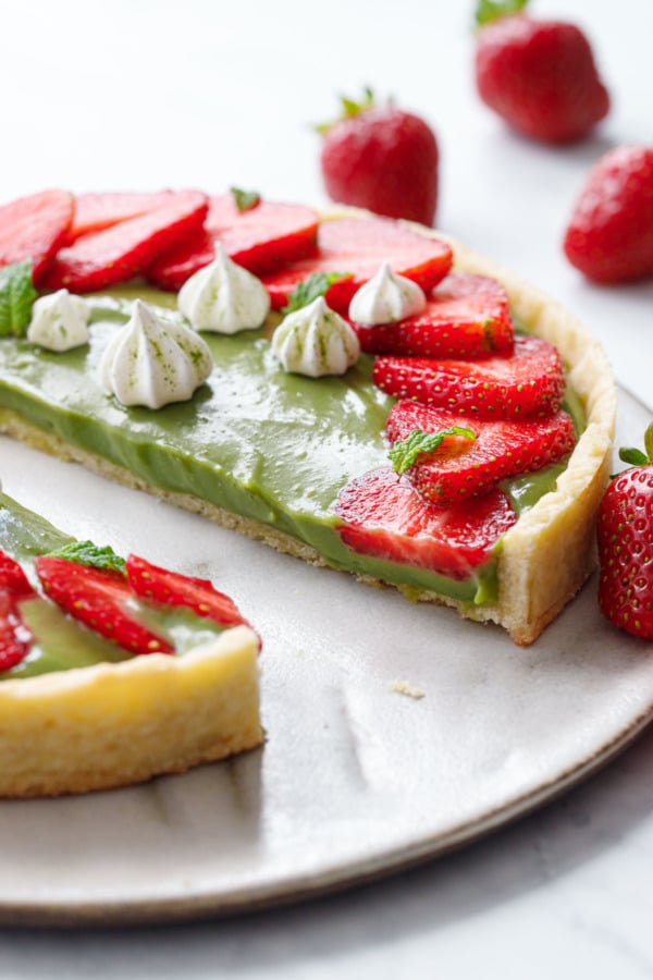 Matcha Strawberry Tart sliced in half to show the texture of the pastry cream filling.