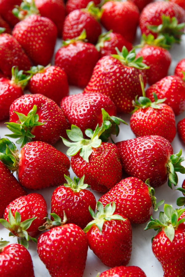 Closeup of freshly picked red strawberries on a marble background.