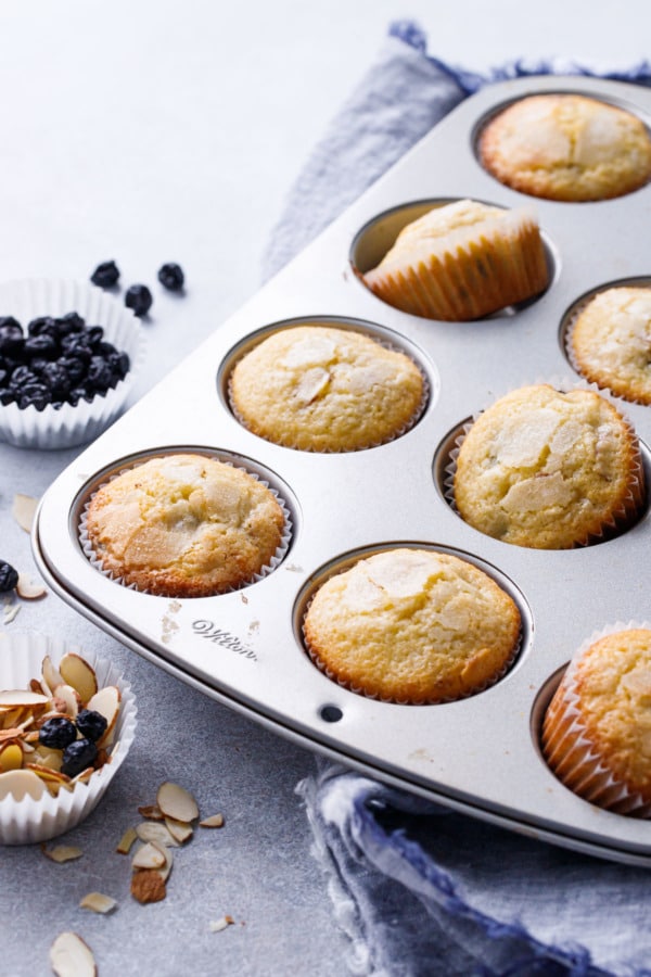 Muffin tin with sourdough muffins with dried blueberries and sliced almonds