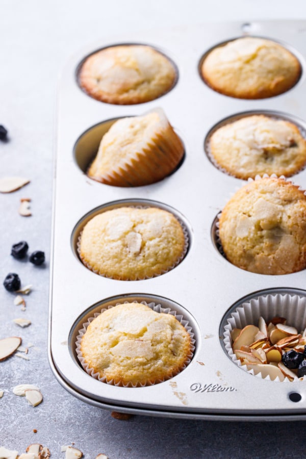 Muffin Tin with Sourdough Muffins with one cup filled with sliced almonds
