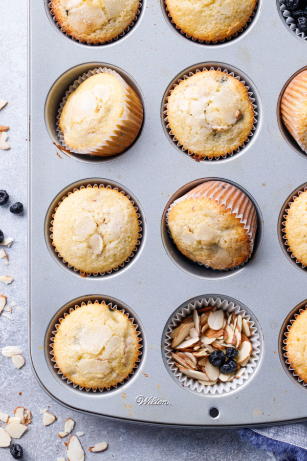 Muffin Tin with Sourdough Muffins with one cup filled with sliced almonds