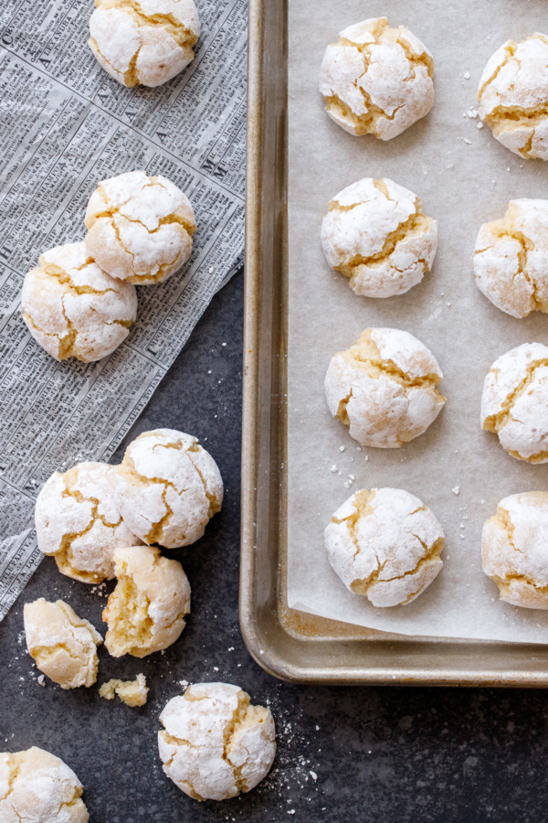 Overhead of sheet pan with amaretti cookies and a few cookies scattered alongside