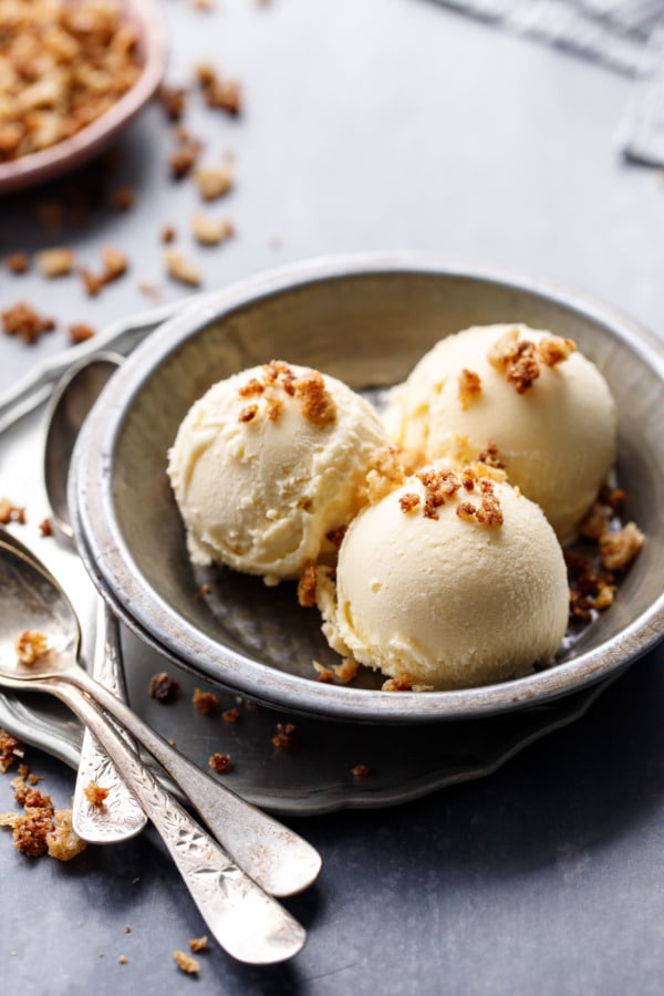 Metal pie tin with three scoops of Sourdough Ice Cream, sprinkled with sourdough breadcrumbs and three spoons on the side.