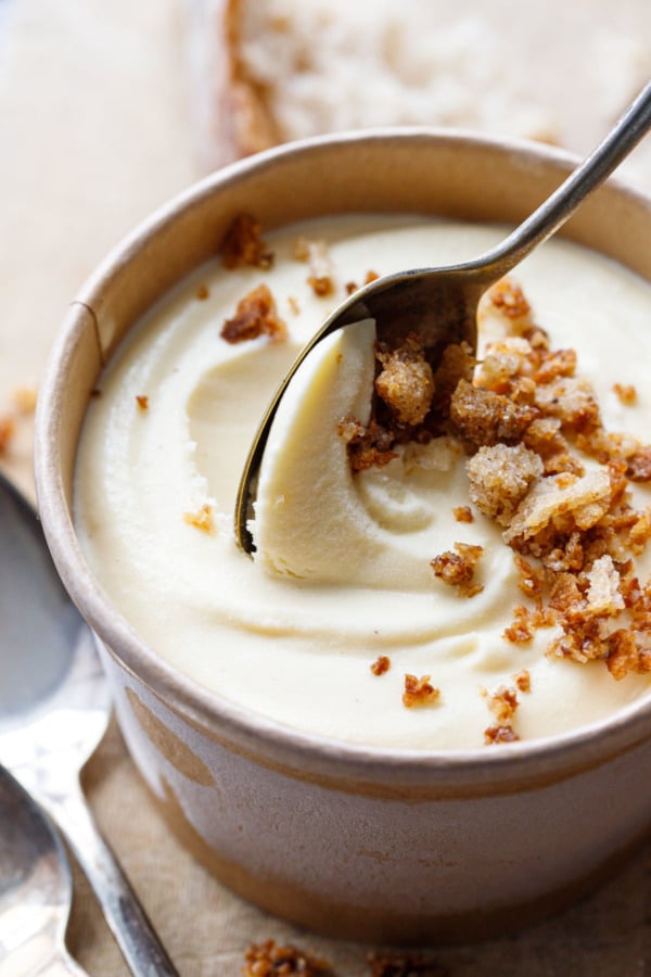 Paperboard pint container of Sourdough Ice Cream with a silver spoon scooping out a spoonful.