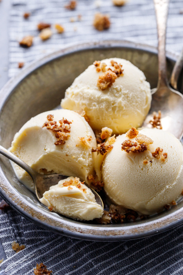 Three scoops of Sourdough Ice Cream in a metal dish with a spoonful on the side.