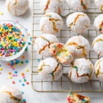 Messy arrangement of funfetti amaretti cookies with broken and bitten into cookies to show texture