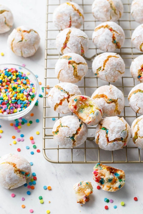 Messy arrangement of funfetti amaretti cookies with broken and bitten into cookies to show texture