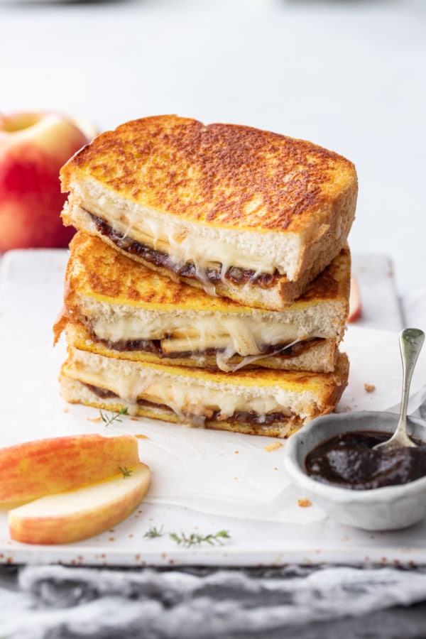 Stack of apple butter grilled cheese halves on a rectangular plate