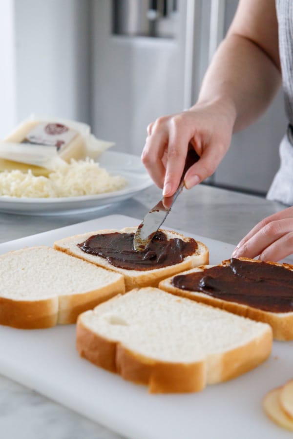 Spreading apple butter onto thick-sliced Texas toast bread