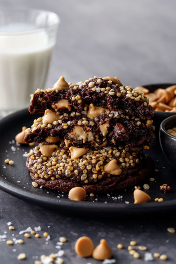 Stack of cookies, one broken in half to show the gooey center and melty peanut butter chips