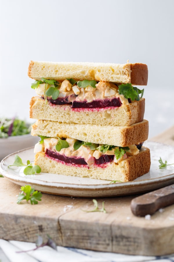 Sandwich cut in half and stacked showing layers of beet and egg salad