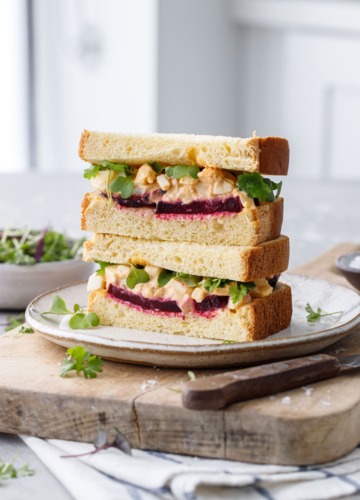 Egg salad sandwich cut in half, showing the layers of beet and egg