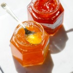 Bright sunlight making the red and orange pepper jelly sparkle