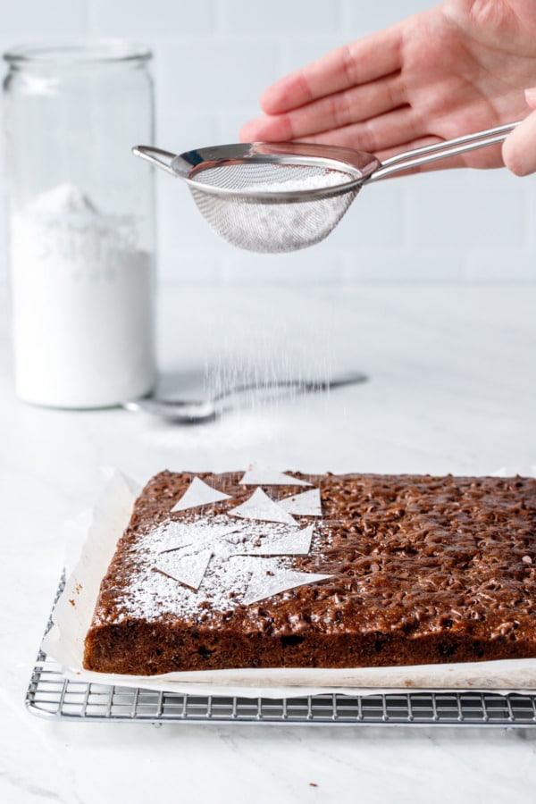 Triangles of parchment set on top of the cake, and powdered sugar dusted on top