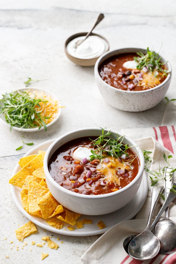 Two bowls of Vegetarian Pumpkin & Three-Bean Chili and 3 vintage silver spoons