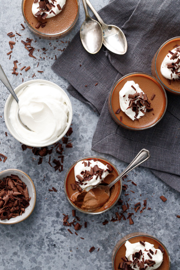 Overhead, Chocolate Pumpkin Pot de Creme with whipped cream and shaved chocolate on a gray background