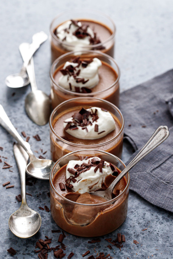 Row of 4 ramekins filled with chocolate pumpkin pot de creme custard