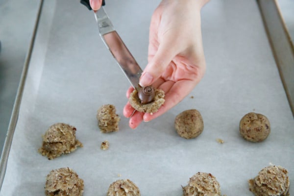 Placing a ball of frozen nutella on flattened half of cookie dough