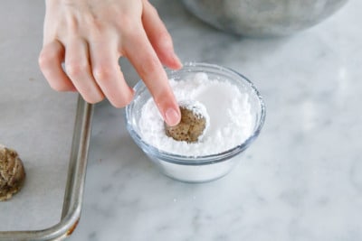 Rolling ball of hazelnut dough in powdered sugar to coat