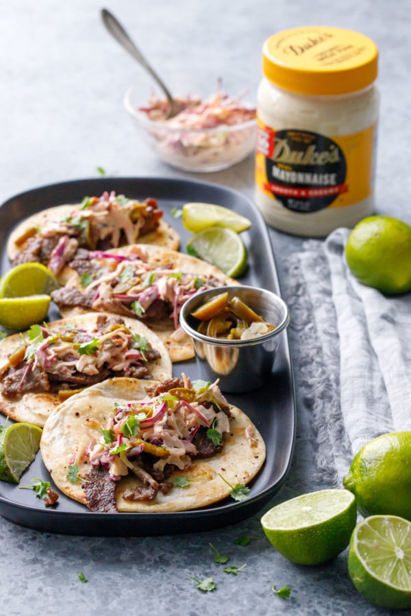 Platter of steak street tacos with jar of Duke's mayonnaise in the background