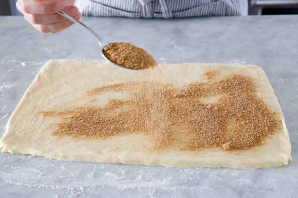 Sprinkling the spiced sugar filling on the dough