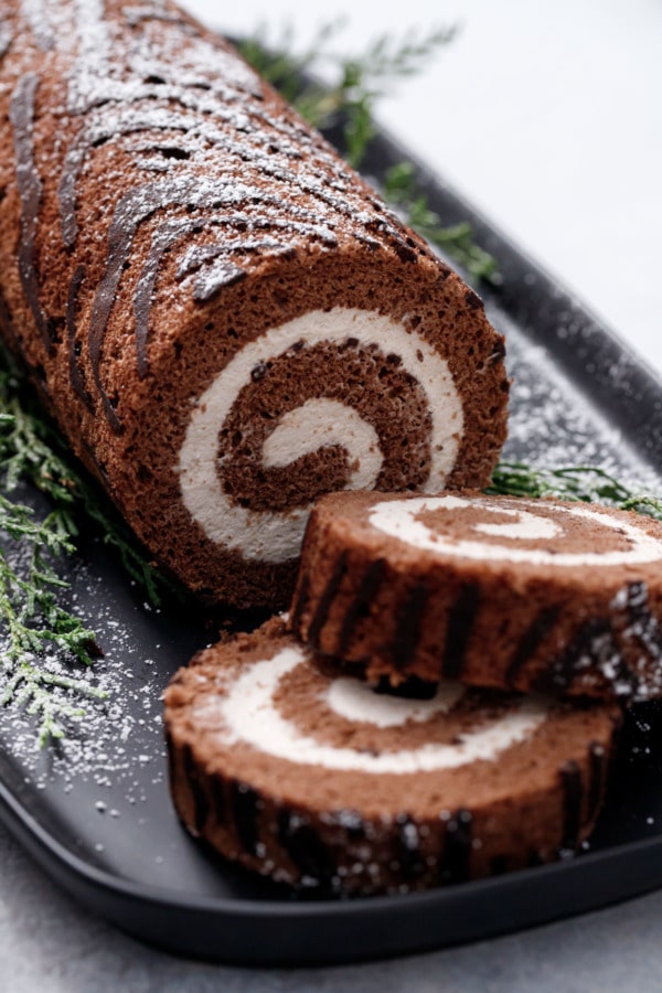 Closeup slices of Chocolate Chestnut Christmas Cake Roll, showing the perfect spiral of filling and the wood grain texture