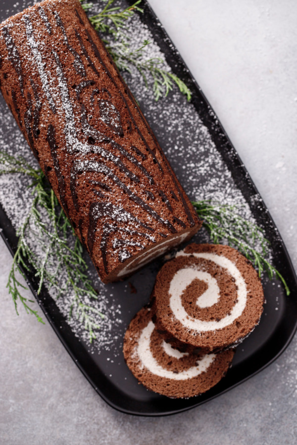 Overhead slices of Chocolate Chestnut Christmas Cake Roll, showing the perfect spiral of filling and the wood grain texture