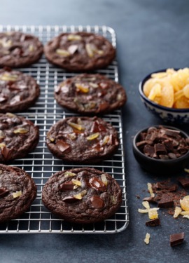 Rows of Double Dark Chocolate Ginger Cookies on a wire rack, with bowls of chopped chocolate and candied ginger.