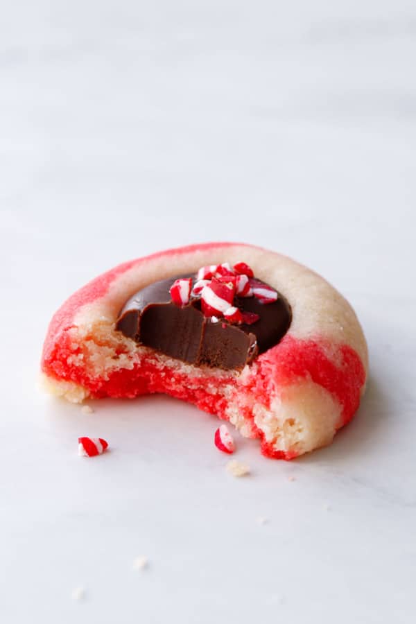 Closeup of Chocolate Peppermint Thumbprint cookie with a bite out of it.