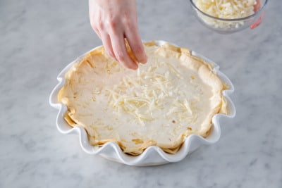 Top quiche with more shredded cheese before baking.