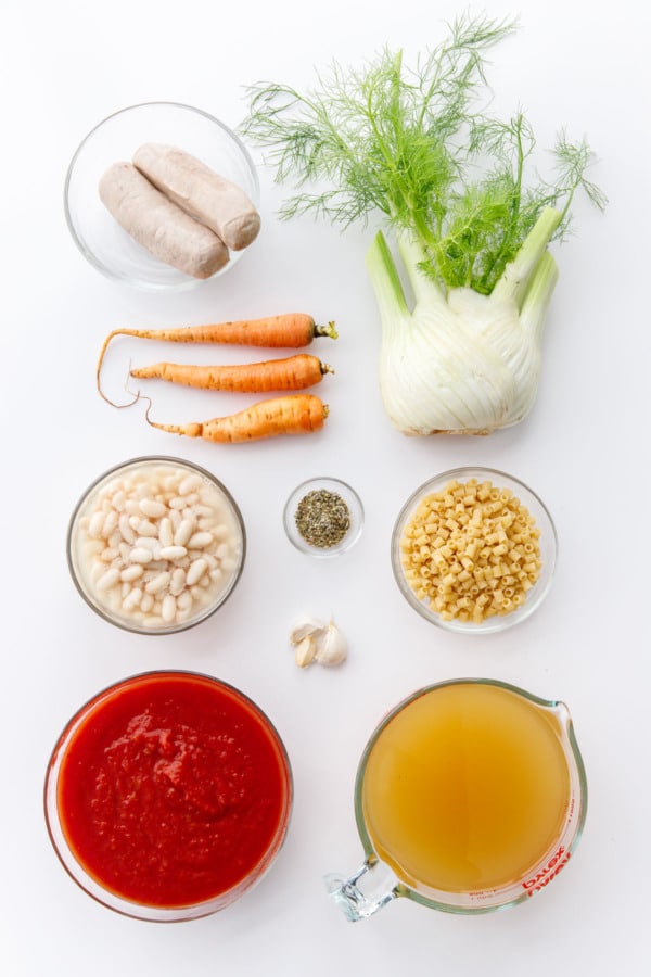 Плоские выложенные ингредиенты на белом фоне, чтобы приготовить суп Pasta e Fagioli
