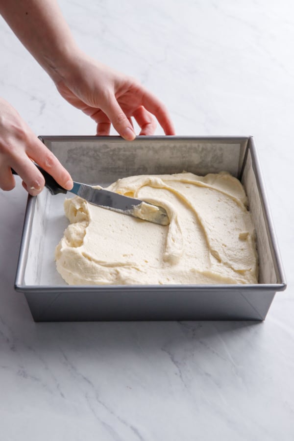Spreading yellow cake batter into a square baking pan