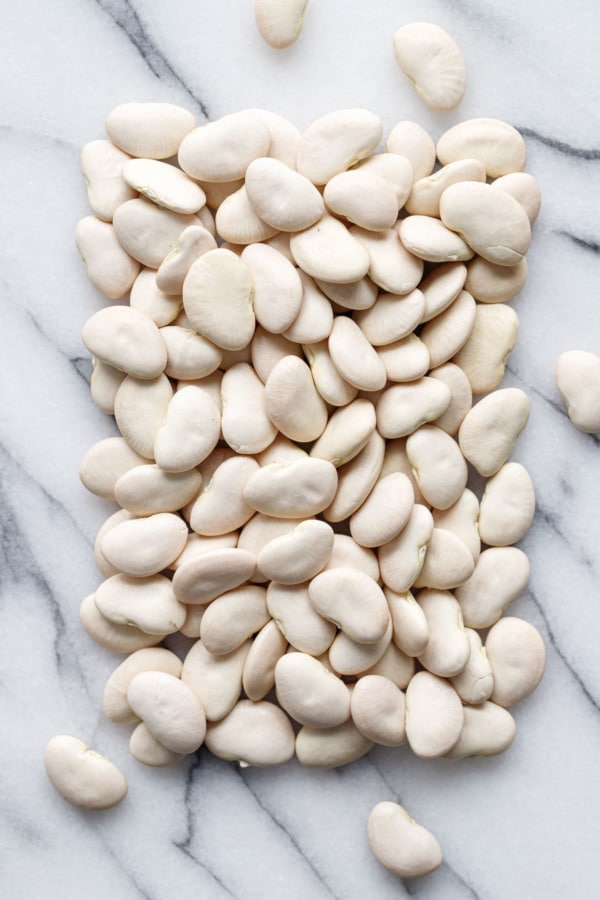Arranged rectangle of dried lima beans on a marble background